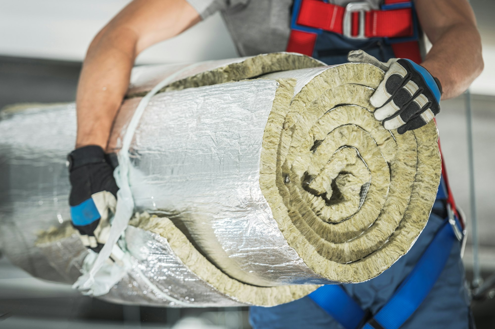 Contractor Worker with Roll of Mineral Wool Insulation